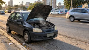 Carro parado no acostamento com o capô aberto e vapor saindo do motor superaquecido Carro parado no acostamento com o capô aberto e vapor saindo do motor superaquecido